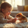 Enfant souriant donnant à manger à un hamster russe dans un salon lumineux