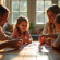 Famille jouant au rummy autour d'une table lumineuse
