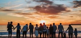 people standing on shore during golden hour